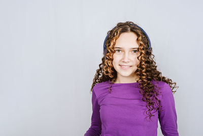 Portrait of beautiful smiling teen redhead girl with curly hair. happy curly teenage girl