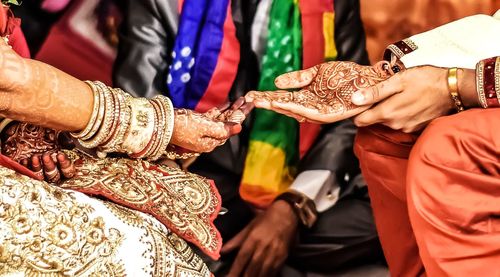 Midsection of friends holding hands at temple