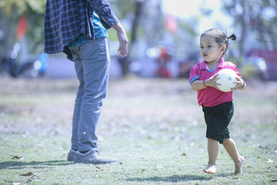 Full length of siblings walking on field