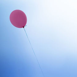 Low angle view of balloons against blue sky