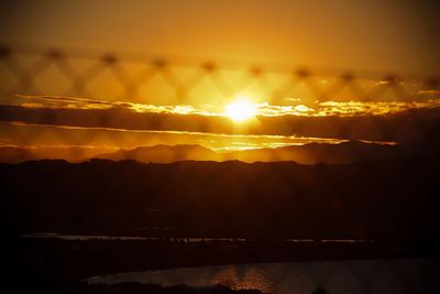 Scenic view of silhouette mountains against romantic sky at sunset