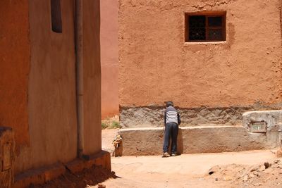 Rear view of man walking on old building