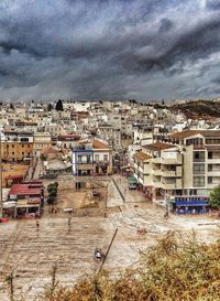 Buildings in town against cloudy sky