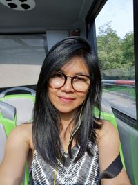 Portrait of woman with long hair sitting in bus