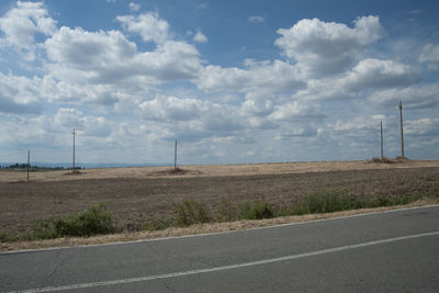 Road amidst field against sky