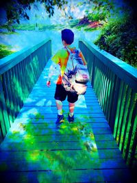 Rear view of woman standing on footbridge