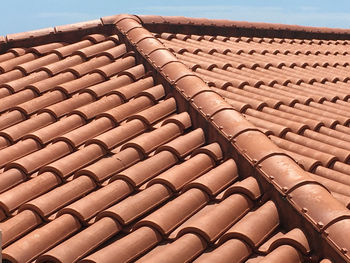 Close-up of roof tiles on building against sky