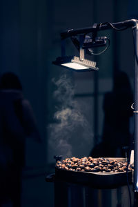 Grillled chestnuts in the night city under street lamp. 