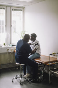 Mature male doctor giving vaccination to boy at hospital