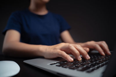 Midsection of man using mobile phone on table