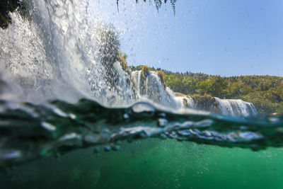 Close-up of water splashing in sea against clear sky