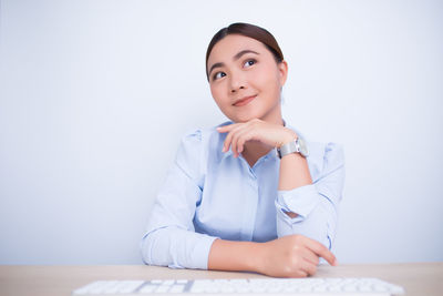 Portrait of a young woman sitting on table