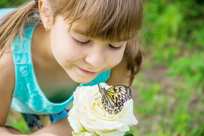 Side view of young woman holding flower