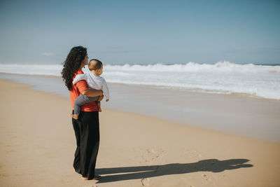 Full length of woman on beach against sky