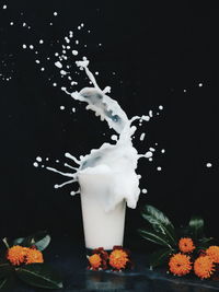 Close-up of water splashing in glass against black background