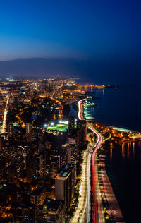 High angle view of illuminated cityscape against sky at night