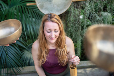 Portrait of smiling young woman standing in yard