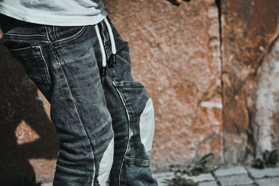 Low section of man standing against wall