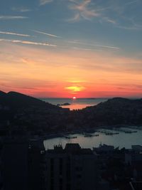 Silhouette city against sky during sunset