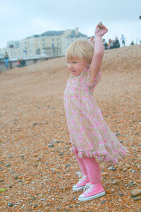 Full length of girl with pink dress standing on land