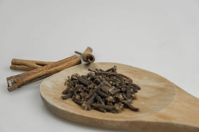 Close-up of coffee beans on table against white background