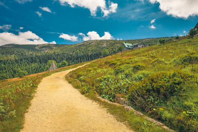Scenic view of road amidst land against sky