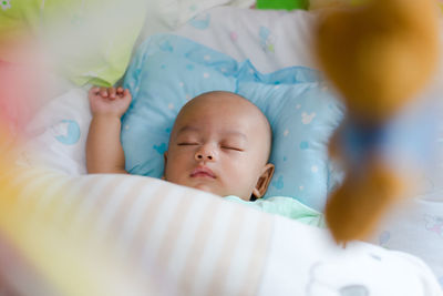 High angle view of baby boy sleeping on bed at home