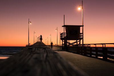 Lifeguard hut on sea against sky during sunset