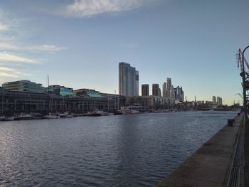 River by buildings against sky in city