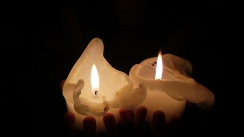 Close-up of lit candle in dark room