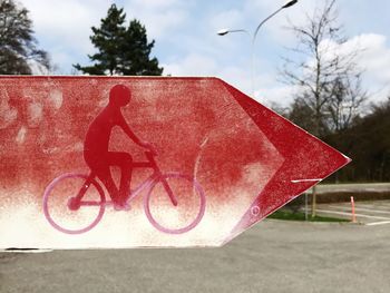 Close-up of road sign against sky