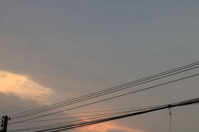 Low angle view of silhouette electricity pylon against sky during sunset