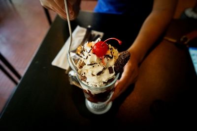 Close-up of hand holding ice cream on table