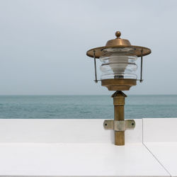 Close-up of coin-operated binoculars by sea against clear sky