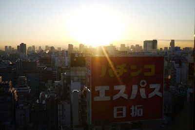 Buildings in city against sky during sunset