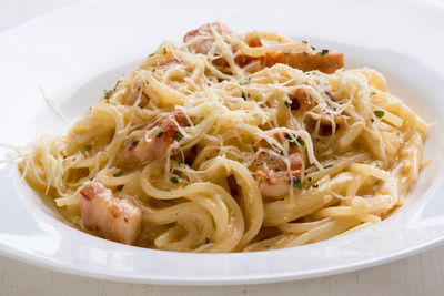 Close-up of spaghetti with carbonara in plate on table