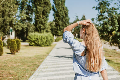 Rear view of woman standing by tree