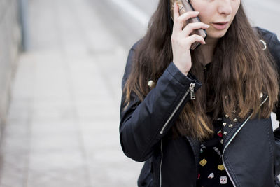 Midsection of man using mobile phone in winter