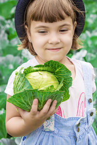 Portrait of cute girl holding leaf