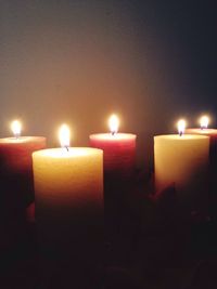 Lit candle in dark room