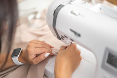 Close-up of woman using sewing machine