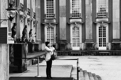 Full length of woman standing in front of building