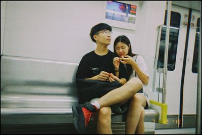 Young man with woman sitting in bus