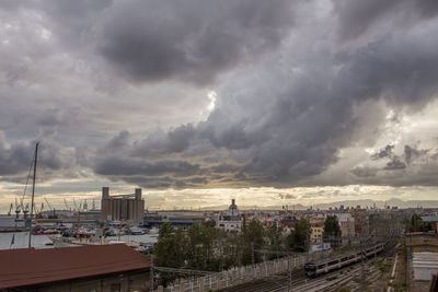 Panoramic view of buildings in city against dramatic sky