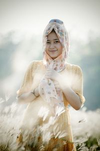Portrait of smiling woman wearing scarf on field