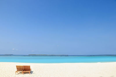 Scenic view of beach against clear blue sky