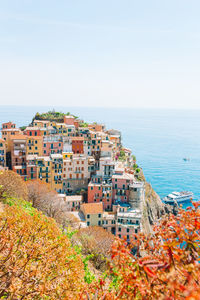 High angle view of buildings by sea against clear sky