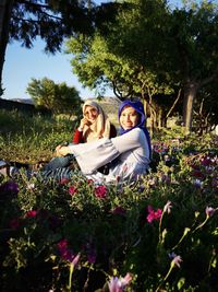 Portrait of women in hijab sitting on field