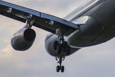 Low angle view of airplane flying against sky