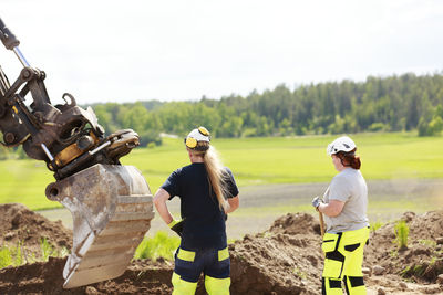Female workers with digger on background